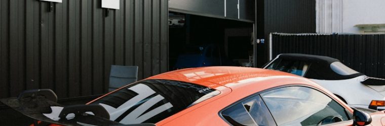 An orange sports car parked in front of a building